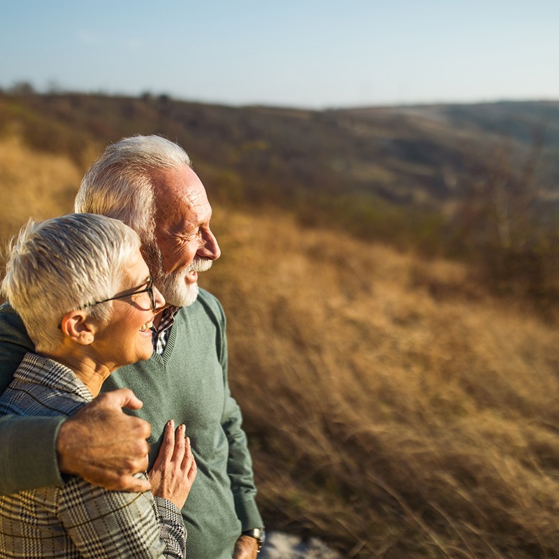 Retired couple on a hill watching the horizon