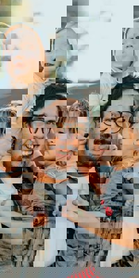 Man with child on his shoulders and other on his hip